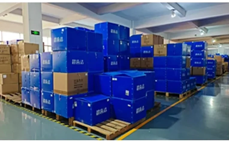 Finished-goods staging. Cartons are palletised by model so a mixed container of irrigators and whitening kits 