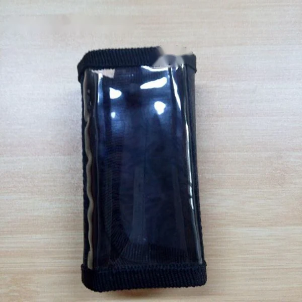 Black fabric pouch with clear plastic window placed on a light wooden table