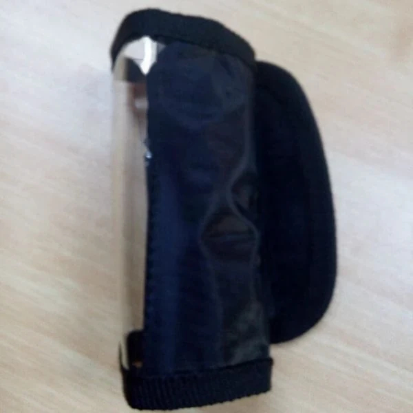 Black fabric armband pouch with clear plastic window lying on a wooden tabletop