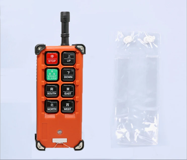Orange industrial radio remote transmitter with STOP, UP, DOWN and direction buttons beside a small clear plastic bag
