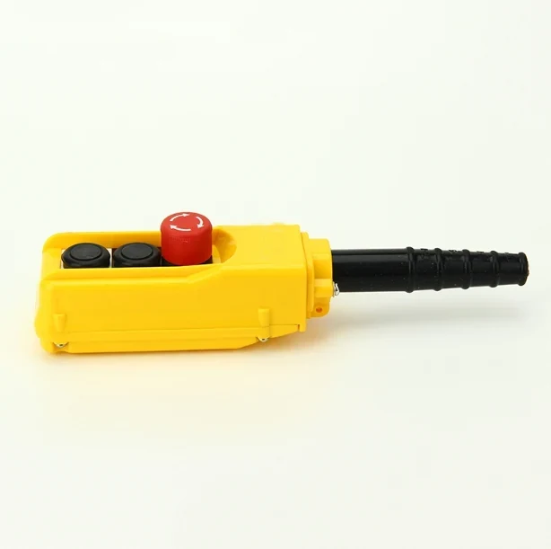 Yellow pendant control station with two black push buttons, red emergency stop button, and black cable gland on white background