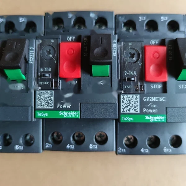 Close-up of Schneider Electric TeSys motor protection circuit breakers showing red stop and green start buttons