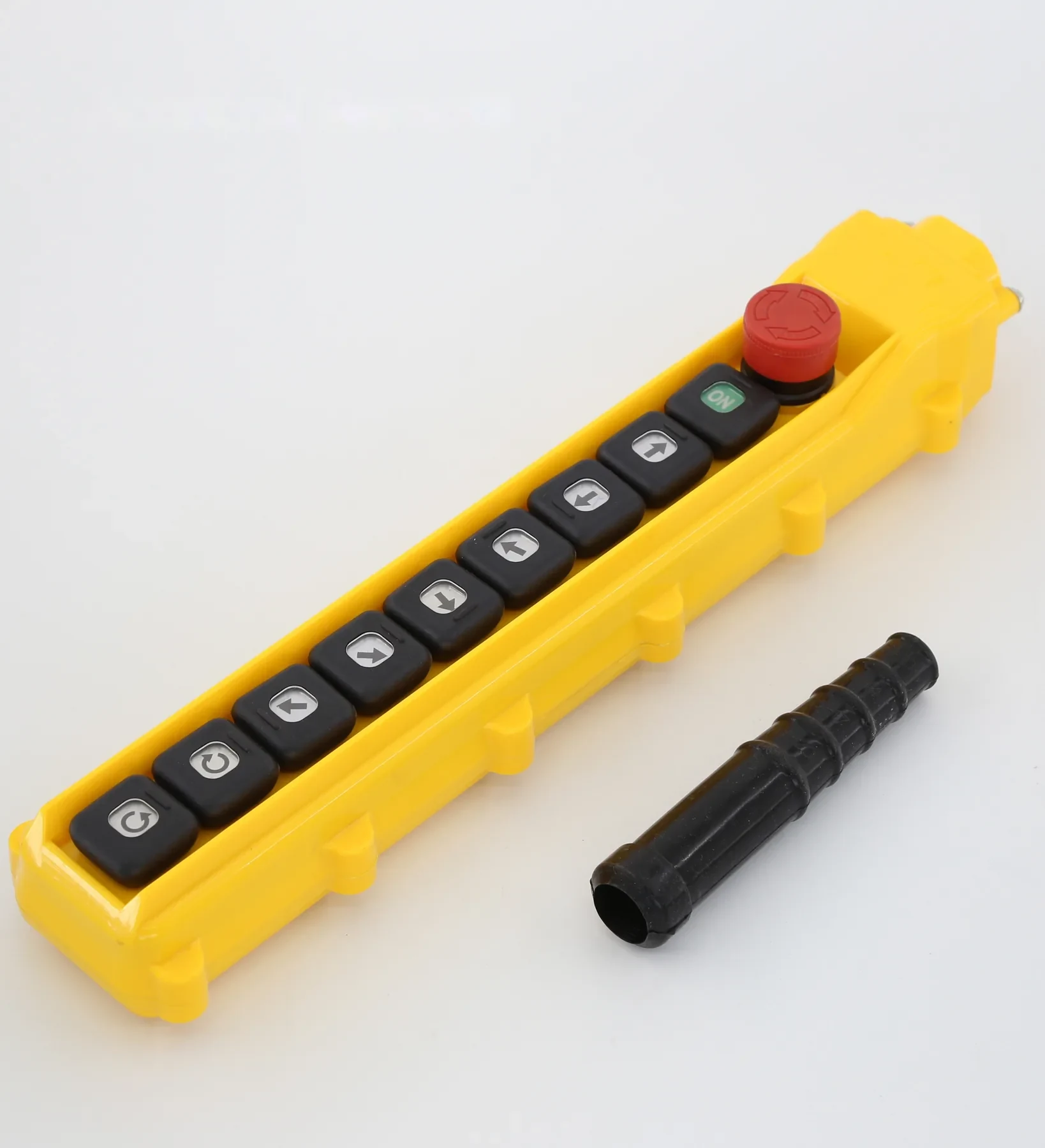 Yellow industrial pendant control station with push buttons and red emergency stop, black cable boot beside it