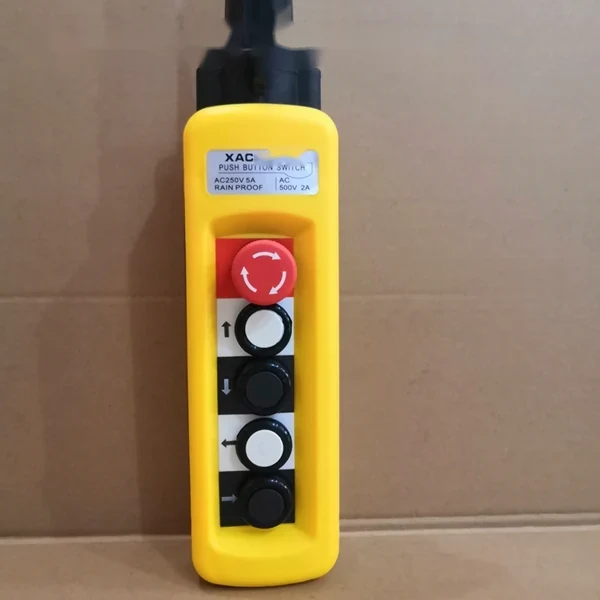 Yellow industrial push button switch with red emergency stop and directional buttons