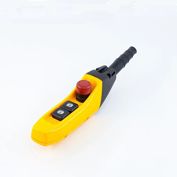 Yellow industrial pendant control station with red emergency stop button and two black push buttons, black cable boot, on white background