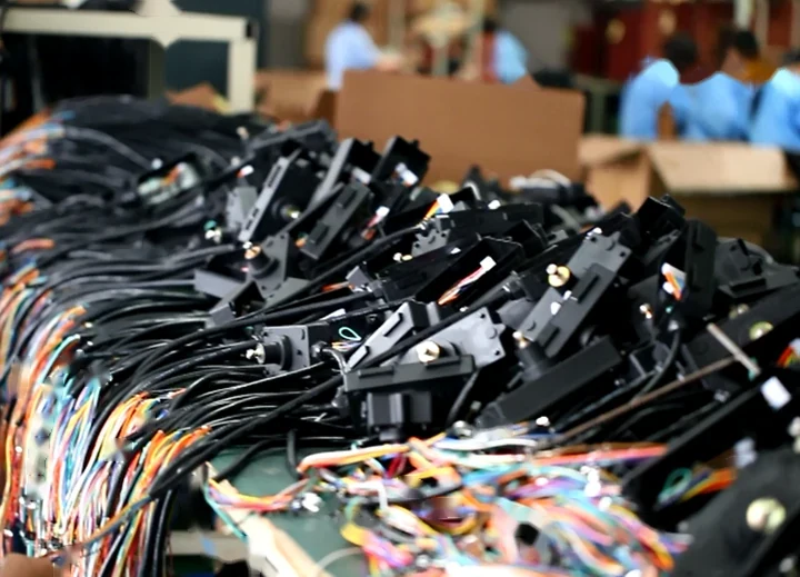 Black electrical components with wire harnesses on an assembly table in a factory