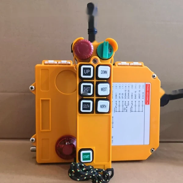 Yellow industrial crane remote control with directional buttons and a schematic diagram