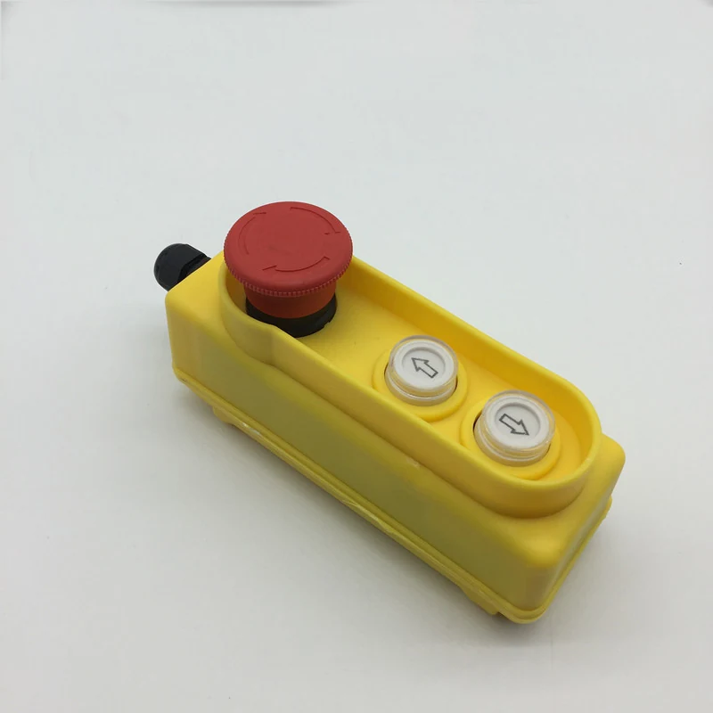 Yellow industrial pendant control station with red emergency stop button and two directional push buttons