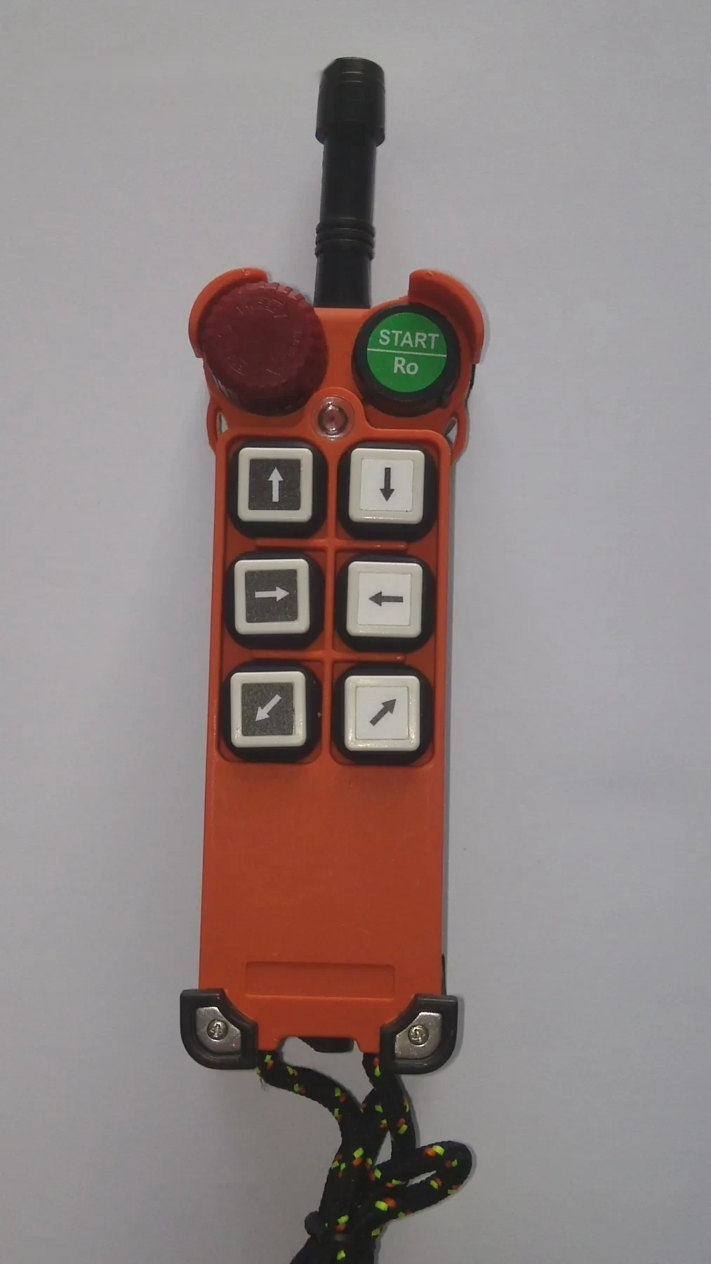 Orange industrial pendant control with red emergency stop, green start button, and directional keys