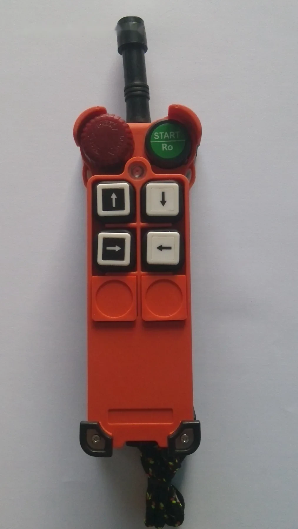 Orange industrial remote control pendant with directional buttons and green start button