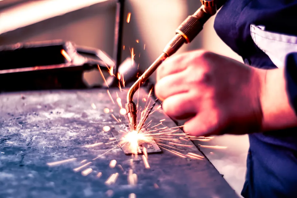 Welder striking an arc with sparks flying from the joint