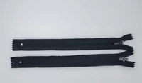 Two black zippers with metal sliders laid horizontally on a white background.