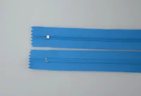 Two blue nylon coil zipper tapes laid parallel on a light gray surface, ends cropped mid-strip
