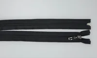 Two black coil zippers on a light gray surface, one with a metal slider and pull, the other detached at one end