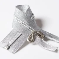 Silver metallic zipper coiled with metal slider and teardrop-shaped pull on a clean white background