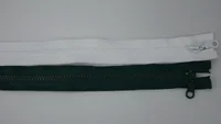 White and dark green nylon coil zippers with sliders laid horizontally on a plain gray background
