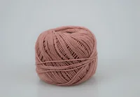 Ball of dusty pink cotton thread wound tightly