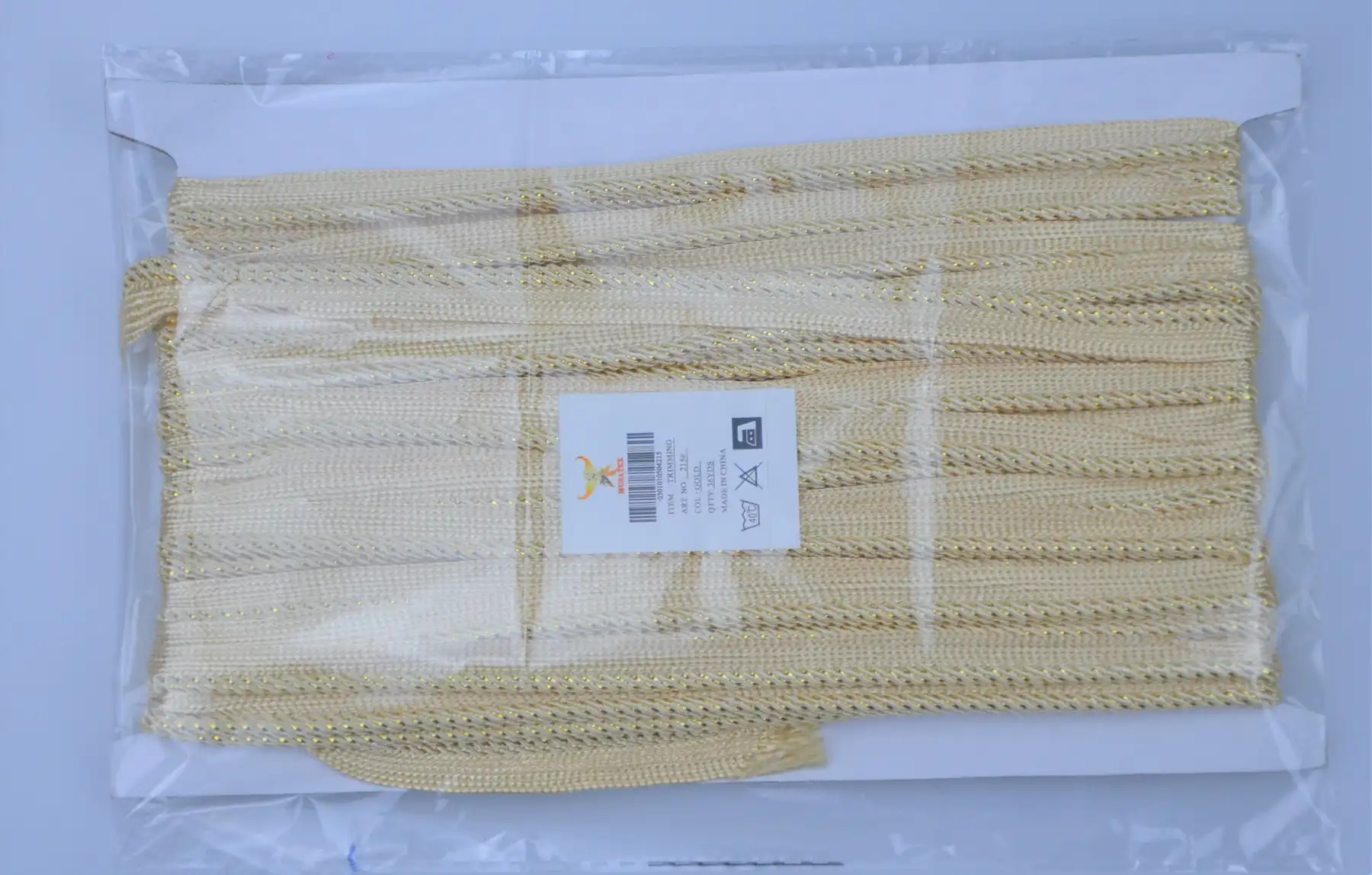 Bundle of gold metallic trim in a clear plastic bag with a label.