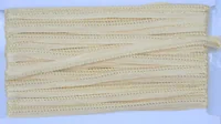 Coiled cream-colored braided trim or flat woven cord laid on a plain white background