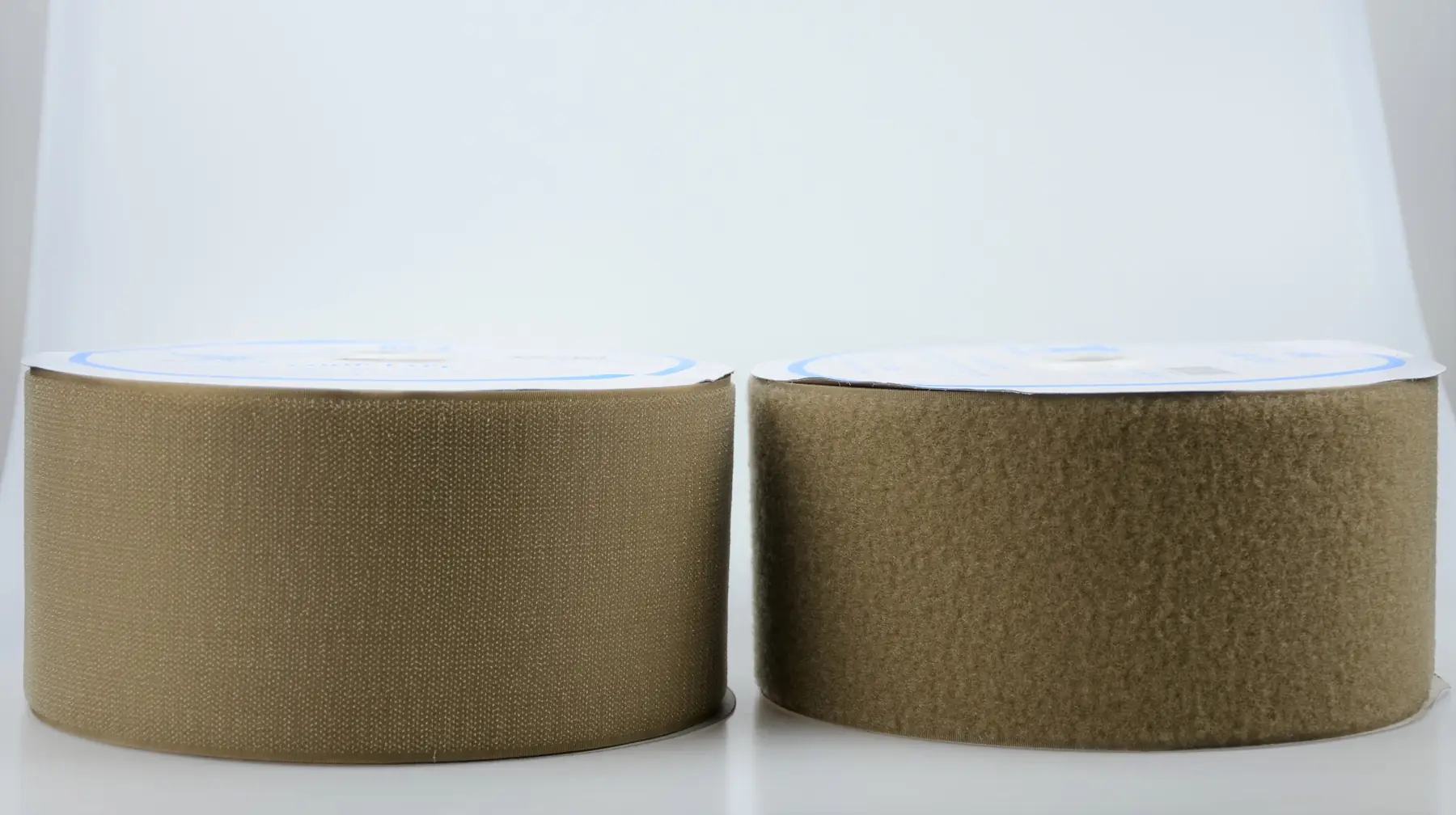 Two tan hook-and-loop fastener tape rolls side by side on a white background