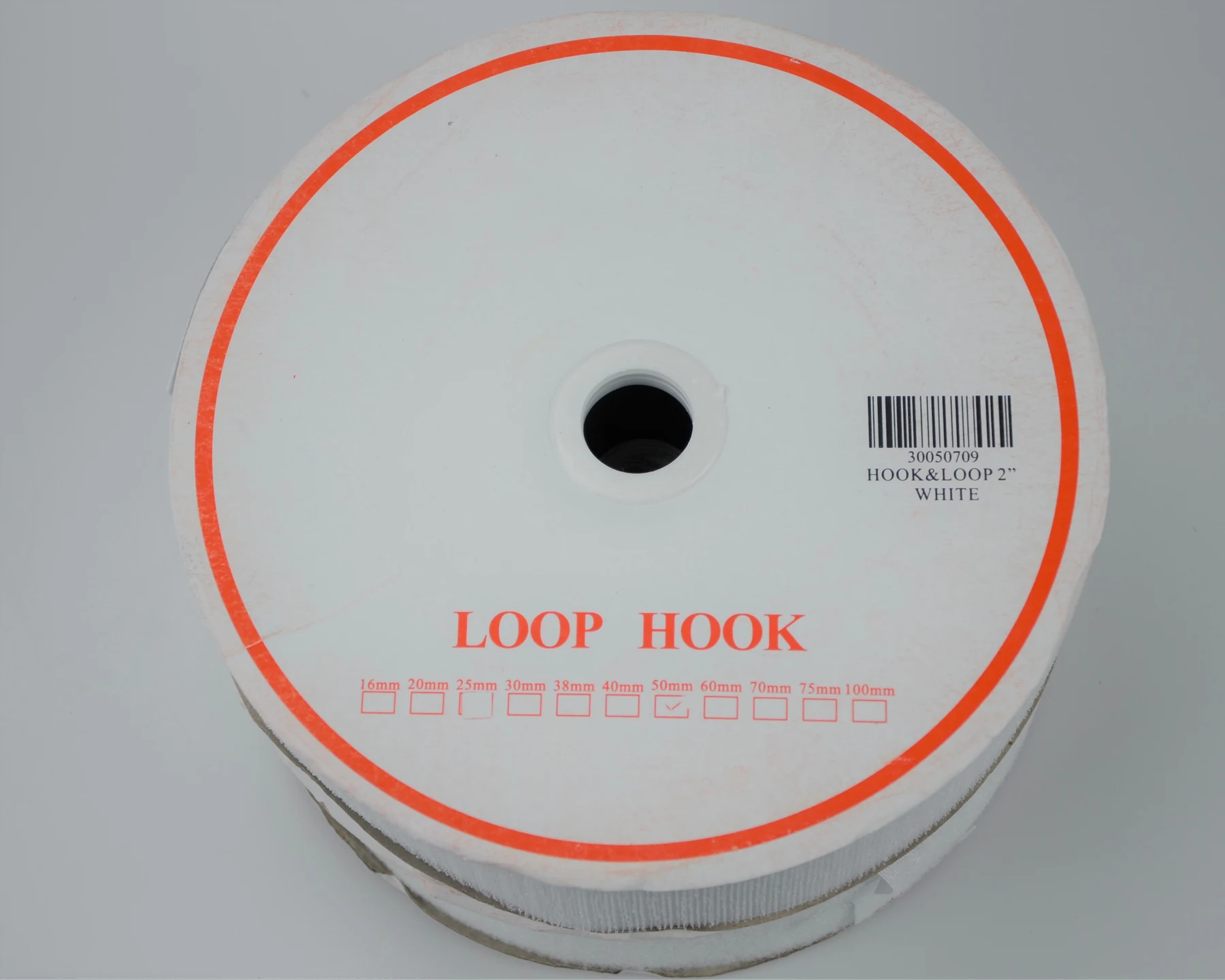 Round white disc of hook-and-loop fastener tape labeled LOOP HOOK with barcode label, on plain background