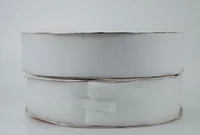 Rolls of white hook-and-loop fastener tape stacked on a plain light background