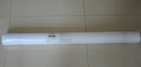 A long roll of white fabric packaging lying horizontally on a tiled floor.