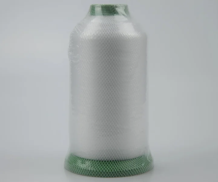Large cone of white industrial thread wrapped in protective mesh, with green plastic ends, on a plain light background