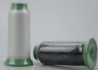 Two yarn cones wrapped in white mesh, one upright white and one lying down dark, on a plain background
