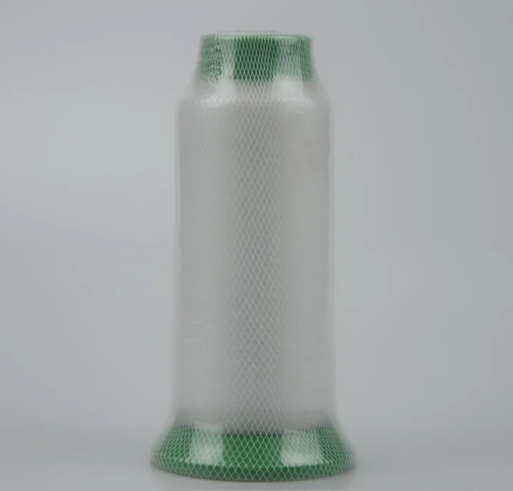 Large spool of white thread wrapped in green mesh netting on a plain gray background