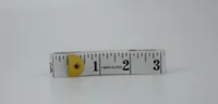 Fiberglass measuring tape coiled on a plain white background with yellow end tab