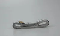 Coiled white measuring tape with black markings and a metal end tab on a plain light background