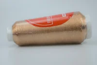 A spool of metallic bronze thread with a red paper label.