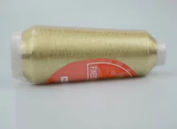 A gold thread cone with a red label resting on a white background.
