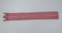 Two dusty pink nylon zippers laid flat on a light gray background