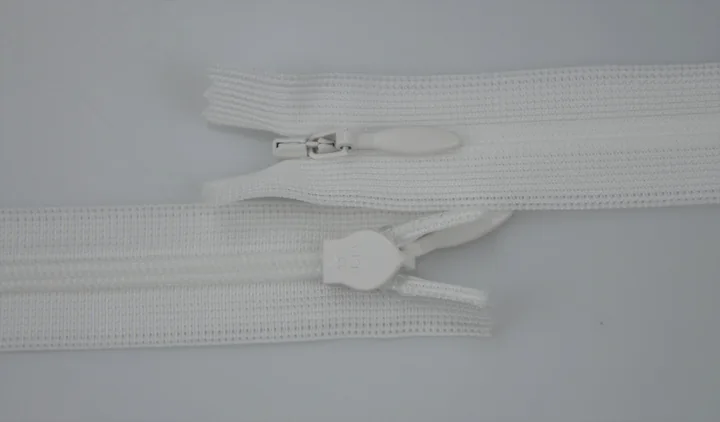 Two white nylon coil zippers with metal and plastic sliders on a plain light background