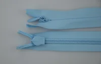 Two light blue nylon zippers with sliders lying on a plain gray background