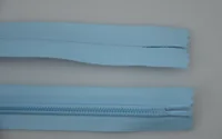 Two lengths of light blue nylon zipper tape on a plain gray background, one showing the coil teeth