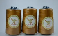 Three golden MUSATEX 100% polyester sewing thread cones with branded phoenix labels on a plain background