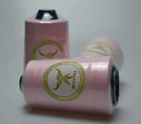 Pink 100% polyester sewing thread cones labelled MUSATEX, Made in China, one lying down