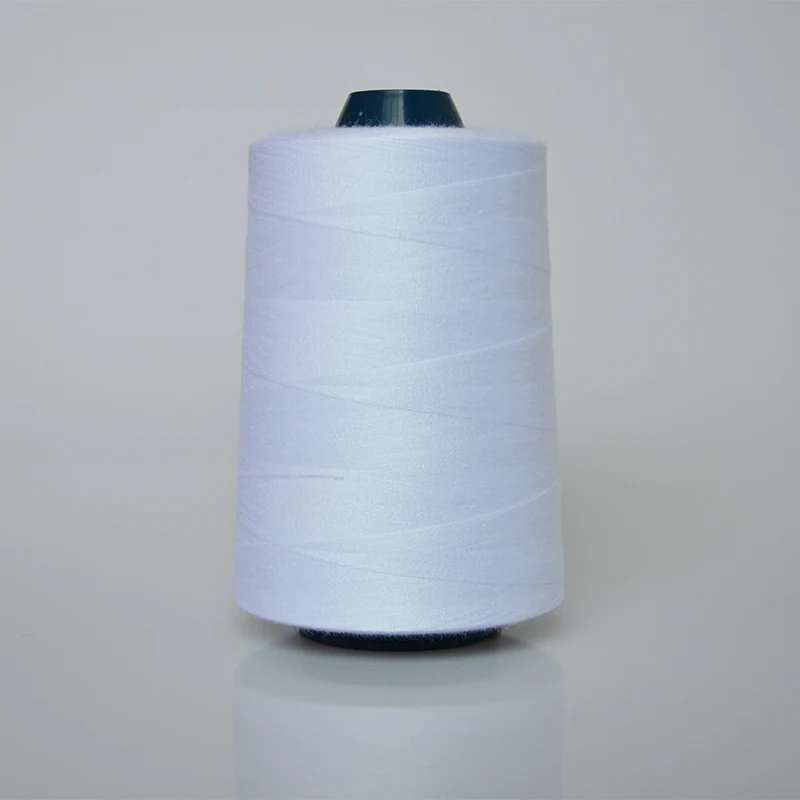 Large cone of white thread with dark teal core on a plain light background