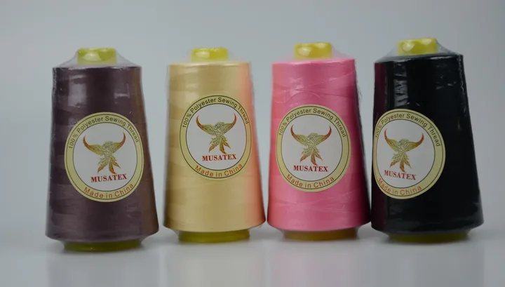 Four MUSATEX 100% polyester sewing thread cones in brown, cream, pink and black on a white background