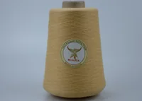 Yellow 100% polyester sewing thread cone with MUSATEX label on gray background