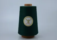 Dark green MUSATEX polyester sewing thread cone with branded label on a plain light background