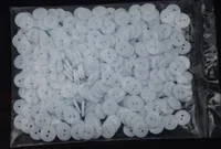 Clear plastic bag filled with small white two-hole buttons