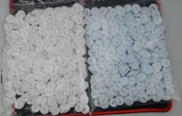 Two bags of small round two-hole buttons, white on the left and light blue on the right