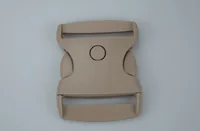 Beige plastic side-release buckle with circular button, centered on a plain light gray background