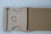 Close-up of a tan plastic side-release buckle attached to a woven tan webbing strap on a plain background