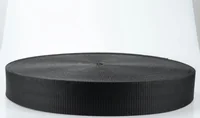 Large roll of black woven webbing strap on a clean white background