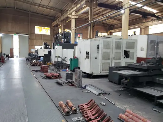 Machining bay with castings staged on the floor between machines at the Anchors Machinery works in Ningbo China